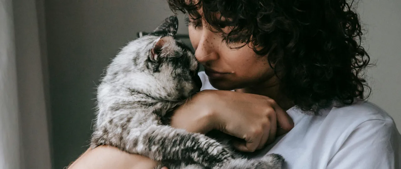 Mujer acurrucando a su gato